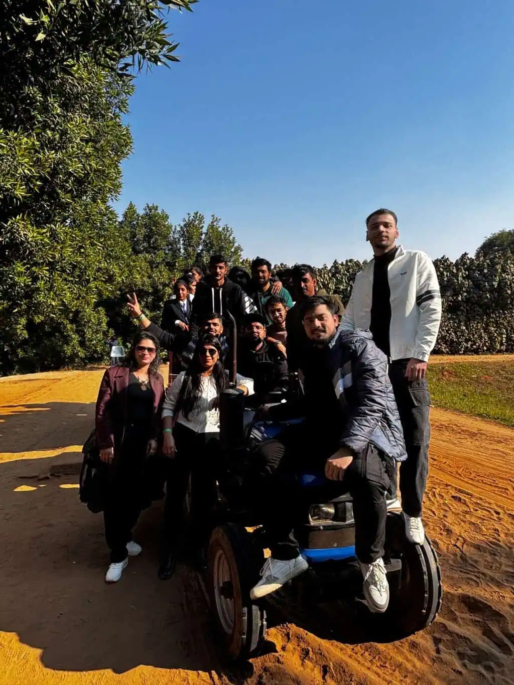 D2i Technology team group photo outdoors surrounded by trees on a sunny day