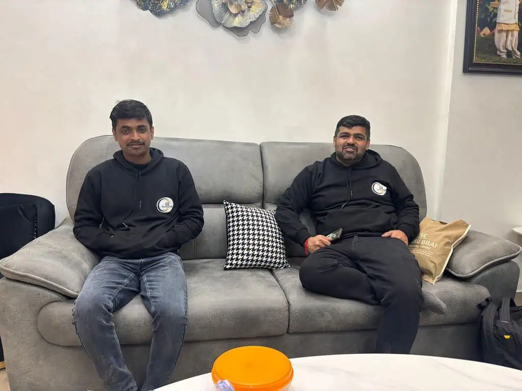Two D2i Technology team members relaxing on a couch during the retreat