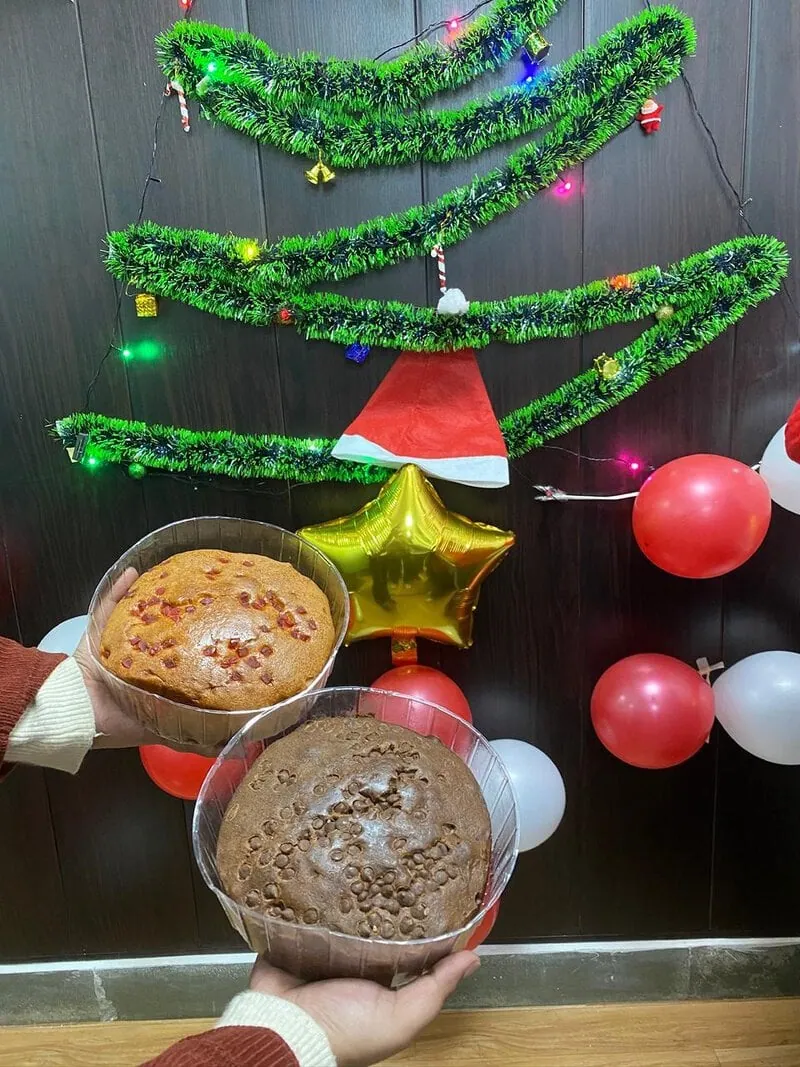 Christmas desserts and cakes on a table decorated with tinsel garland and balloons.