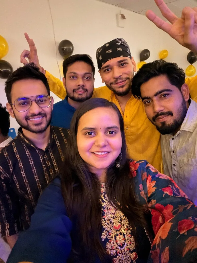 Selfie of four colleagues smiling at a festival celebration.