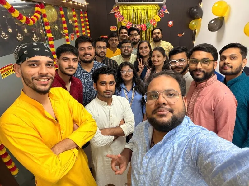 Selfie of a large group of colleagues in kurtas at a festival party.